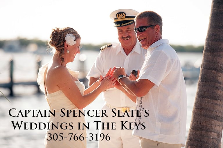 Captain Spencer Slate conducting a beach wedding ceremony with bride and groom in casual white attire by the water